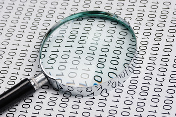 magnifying glass on a binary code