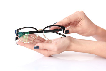 Fototapeta na wymiar Female hands holding eye glasses on white background