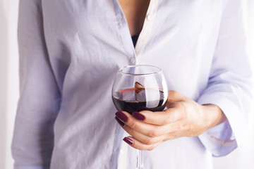girl in a shirt with a glass of red wine