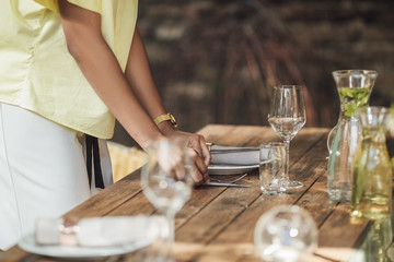 Woman Decorating Table For Outdoor Dinner Party