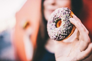 Close-up of women holding chocolate donut in her hands