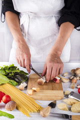 female hands cut prepare ingredients for pasta with mushrooms