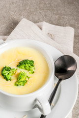 Broccoli, cheese and chicken soup, on gray stone table, copy space