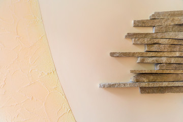 Narrow decorative stone on the left on a beige wall