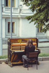 street musician playing the old shabby piano