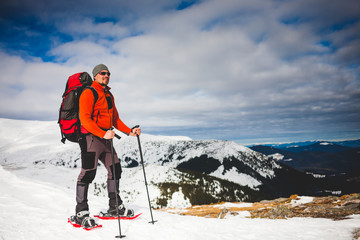 Male tourist in snow snowshoes.