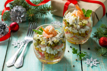 Homemade snacks on a festive Christmas table. Salad with shrimps, crab sticks, egg and corn.