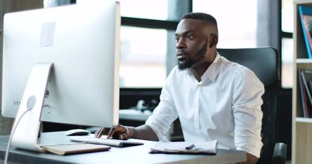 Young black man working use computer in office smiling technology african american businessman casual communication entrepreneur male successful person portrait smart business Slow Motion Shot - Powered by Adobe