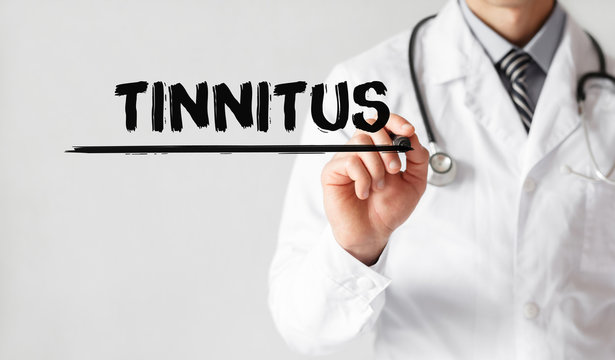 Doctor writing word Tinnitus with marker, Medical concept