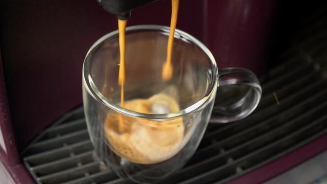 Coffee machine filling a cup with hot  coffee