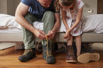 Father teaching his daughter to tie shoelaces