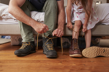 Dad teaching his daughter how to tie shoelaces, low section