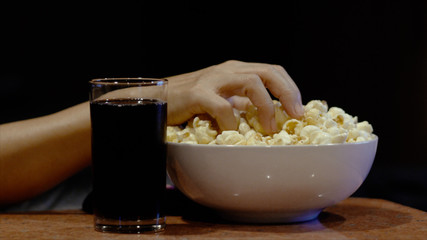 The man eating popcorn and watching movies relaxed in living room