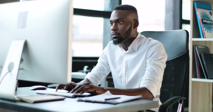 Attractive young black man working use computer feels frustrated sad office technology african american businessman casual communication successful person portrait smart business Slow Motion Shot