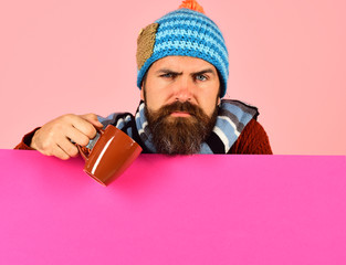 Man with beard holds brown cup of curing powder.