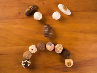 Traditional brazilian sweets - brigadeiros - over wood background.