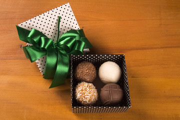 Traditional brazilian sweets - brigadeiros - over wood background.