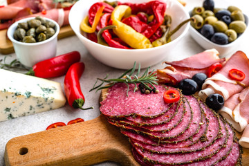 Table with food from spain, salami slices, ham and other spicy appetizers, mediterranean diet