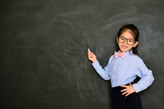 smiling little teacher standing in blackboard