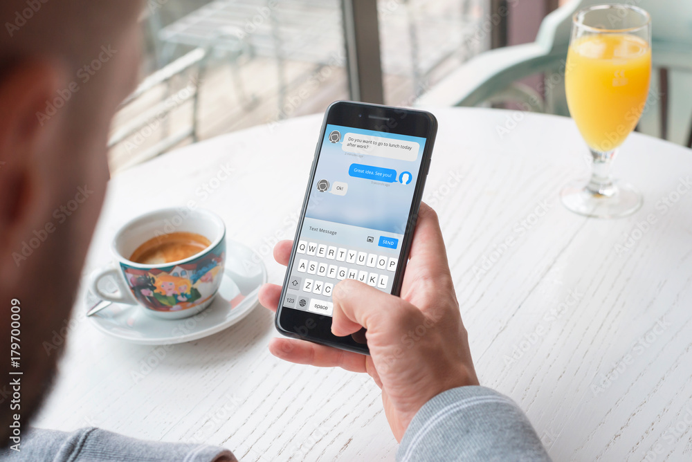 Aufkleber Sending messages from a mobile phone. Man use smartphone to schedule a lunch with a business partner.