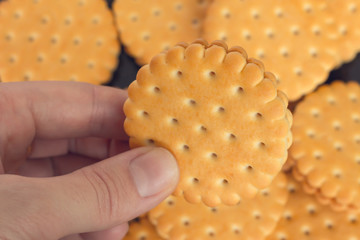 people, junk food, culinary, baking and unhealthy eating concept - close up of hands with cookies