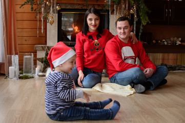 Happy family near the fireplace with New Year's decorations. Merry Christmas. Happy New Year.