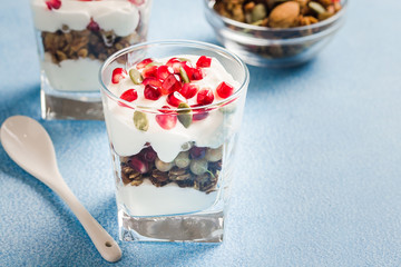 Winter fruit  breakfast granola parfait on light blue background. Selective focus, space for text. 