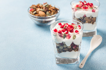 Pumpkin seeds  mixed berries granola parfait on light blue background. Selective focus, space for text. 