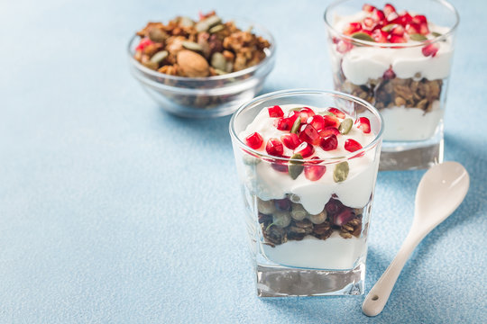 Pumpkin seeds  mixed berries granola parfait on light blue background. Selective focus, space for text. 