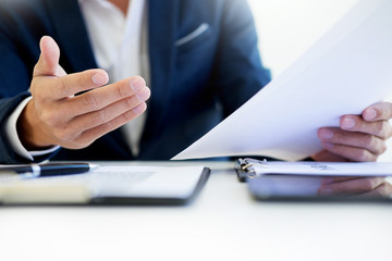 Man signing a car insurance policy, the agent is holding the document.