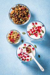 Healthy homemade granola parfait on light blue background. Top view, copy space.