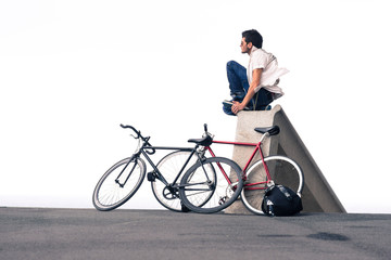 Obraz premium man sitting next to his bike on the street