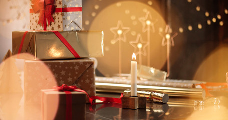 Beautifully wrapped Christmas presents on the background of stylish decorations and lights in warm golden and red tones