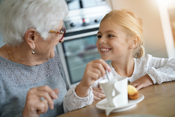 Obraz na płótnie Canvas Little girl having tea time with grandma