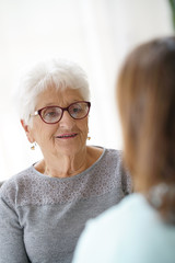 Nurse talking to old woman, assistance and support