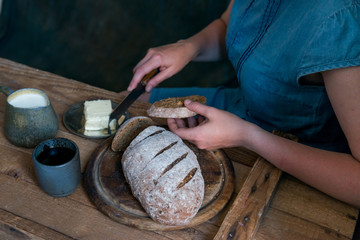 Obraz na płótnie Canvas Woman puts butter on rye bread breakfast concept
