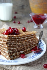 Russian pancakes with cranberry jam on a plate