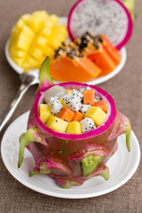 Fresh tropical fruit salad in dragon fruit skin, close up