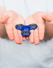 Fototapeta premium young man playing with a fidget spinner, focus on hand.