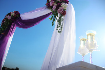 wedding arch and glasses against the background of water