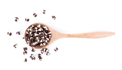 Chocolate chip morsels spread in wooden spoon on white background