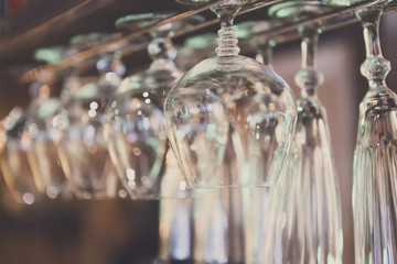 Glasses hanging on bar rack close up