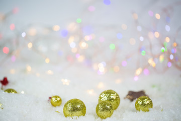 Christmas tree balls in the snow, lights in the background