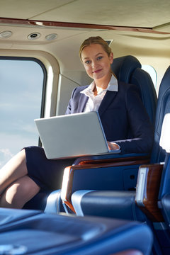 Portrait Of Businesswoman Working On Laptop In Helicopter Cabin During Flight