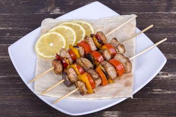 Grilled meat and vegetables on skewer in the plate