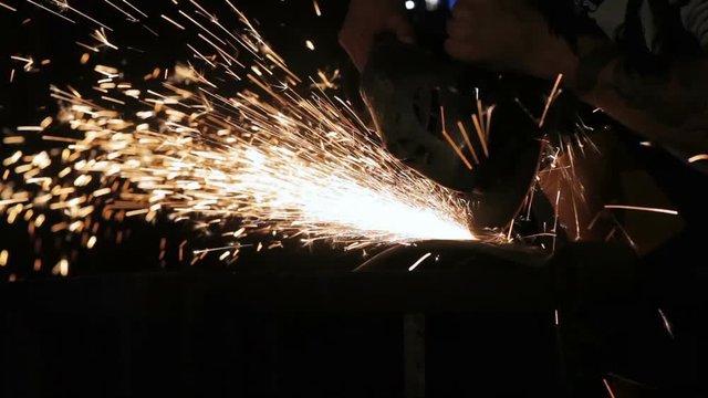 Sparks from the angle drive grinder against a dark background