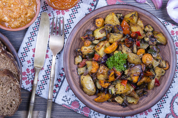 Stewed vegetables in a white bowl on wooden table. Close up