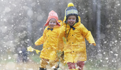 Toddlers on a walk in the autumn park. First frost and the first