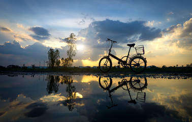 Fototapeta na wymiar Reflection of Silhouette bicycle park on the waterfront
