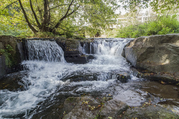 Waterfall in a river between rocks and trees 